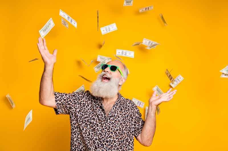 A happy man with money falling around him, representing the excitement of checking and receiving a tax refund status.