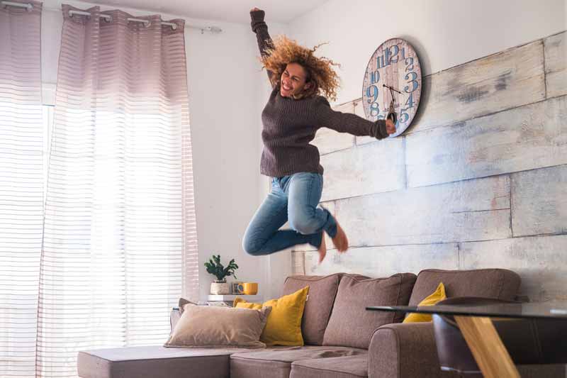Excited woman celebrating a bigger tax refund after adjusting her W-4 form.