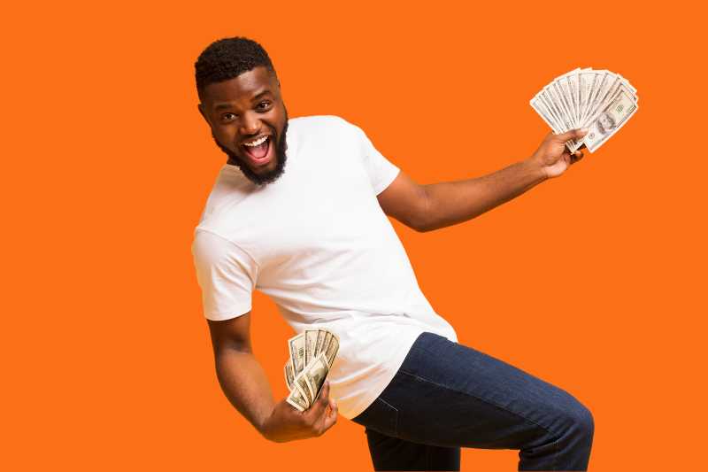 Happy man dancing with money in his hands, celebrating a fast tax refund after using tips for quick processing and faster returns.