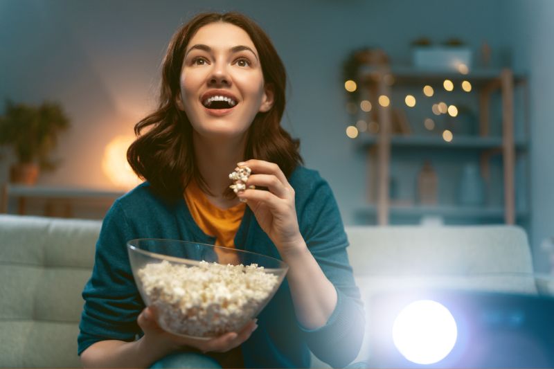woman eating popcorn watching a movie