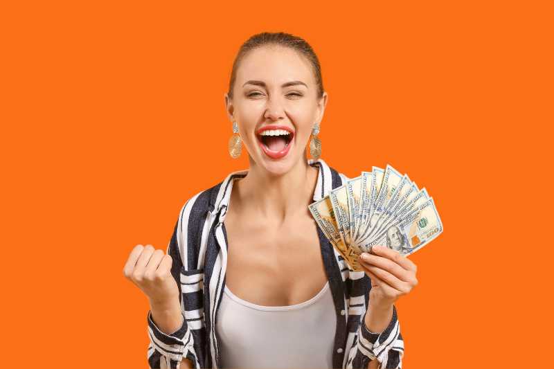 mujer excitada con dinero en la mano