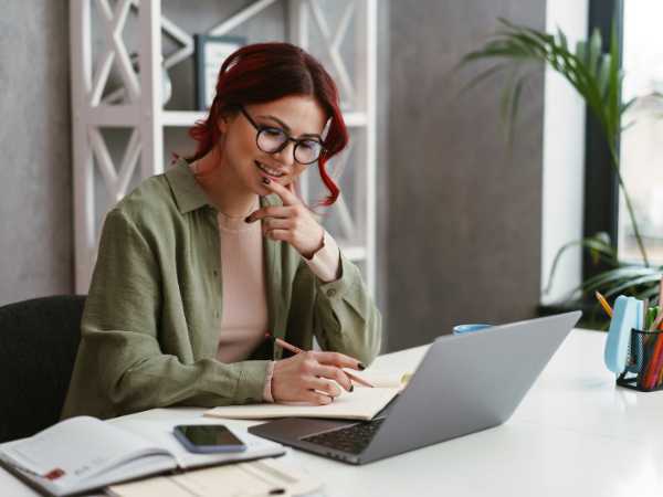 Woman thinking at her laptop, deciding between standard vs. itemized deductions to save more on taxes this year.
