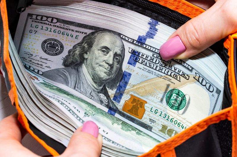 Wallet filled with $100 bills, symbolizing a large tax refund and financial savings.