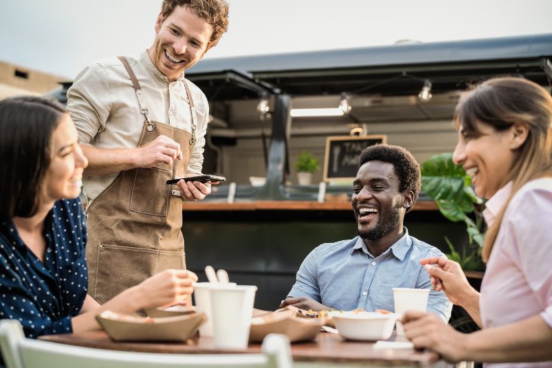 A waiter taking customer orders, representing the importance of understanding taxable tip income and how to report tips accurately.