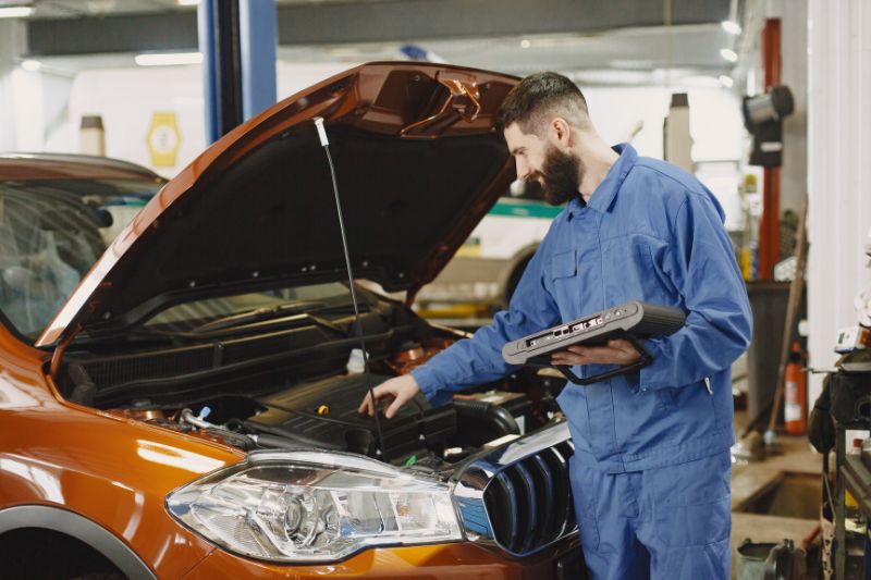 A mechanic inspecting the engine of a car, representing the topic of whether car repairs are tax deductible.
